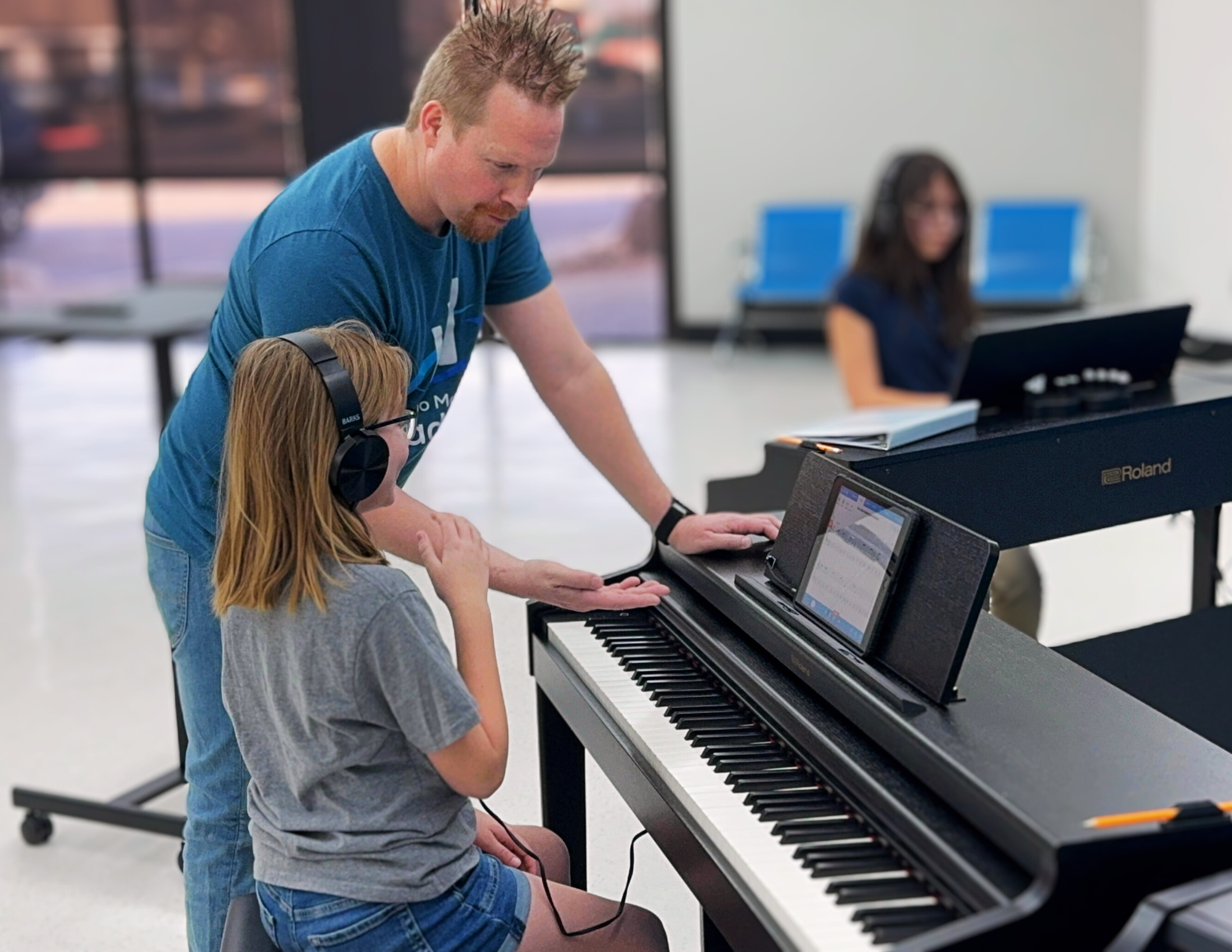 2 Piano student receiving individual instruction at a digital piano with headphones at Piano Marvel Academy in Lubbock