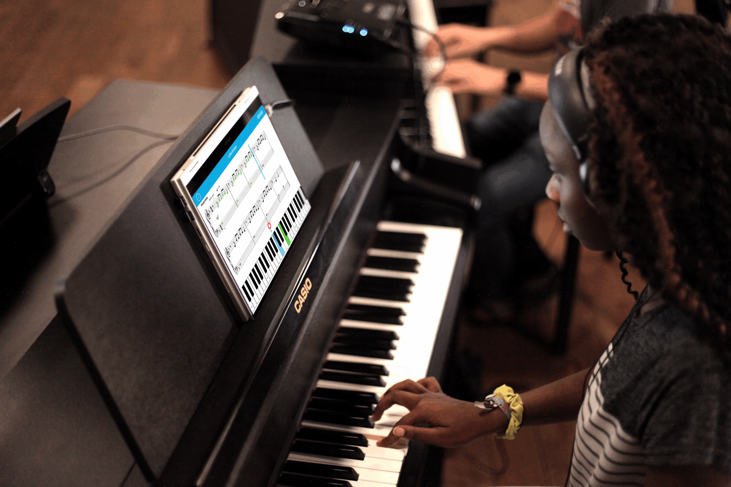student-using-piano-marvel-group-class.png Student using Piano Marvel software on digital piano in group class setting with headphones