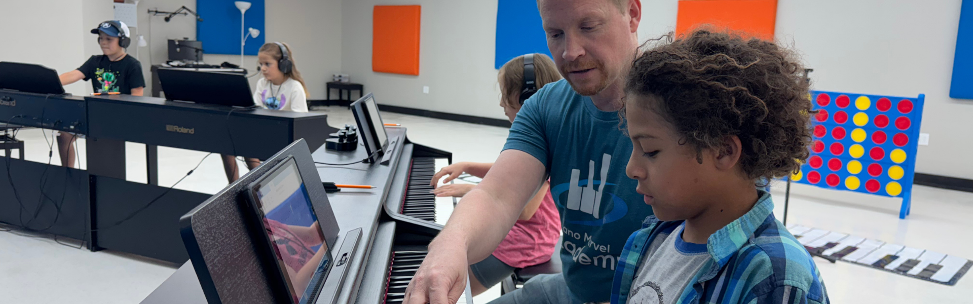 Group Class Piano teacher giving individual feedback to student during group piano class at Piano Marvel Academy Lubbock