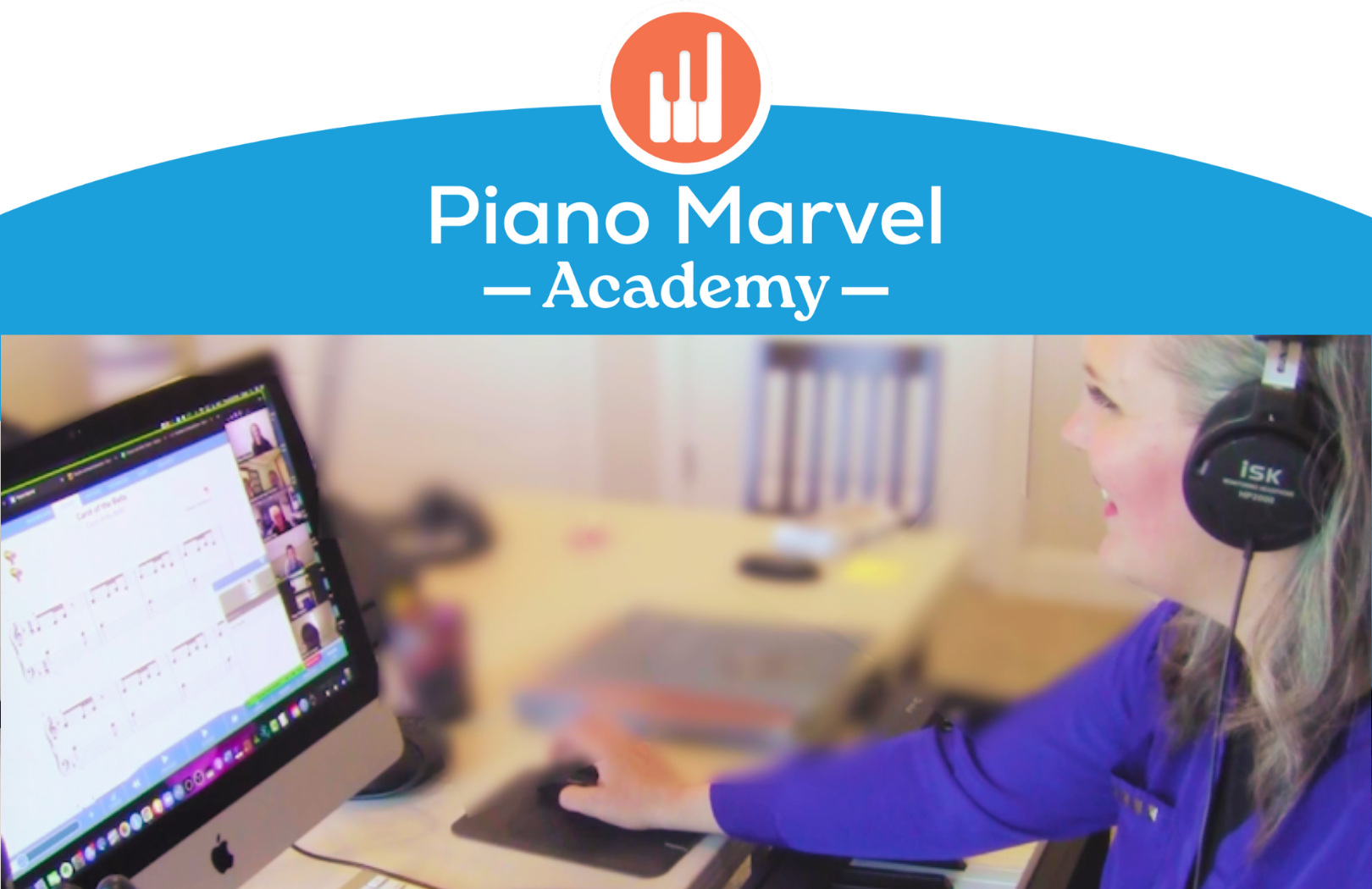 Untitled design (21) Smiling piano teacher wearing headphones teaches a virtual piano lesson using Piano Marvel software on a desktop computer. The top of the image features the Piano Marvel Academy logo with an orange and white piano icon and bright blue banner.
